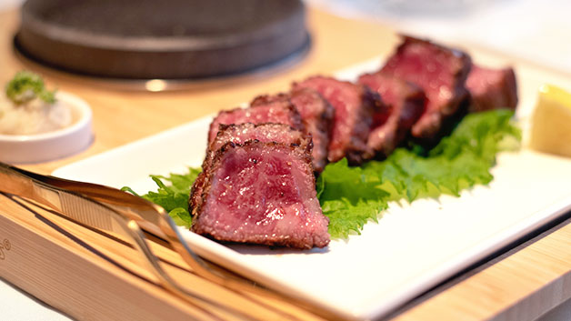 wagyu style steak on a bed of lettuce on a plate
