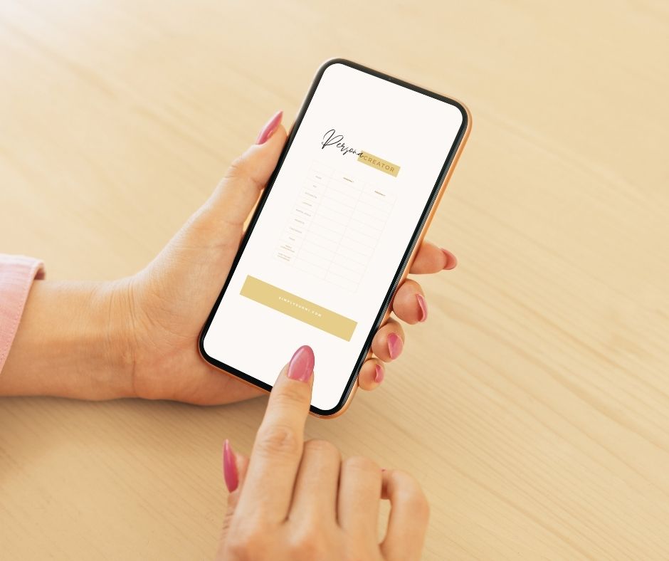 A female hand with pink nails holding a phone and downloading the Persona Creator.