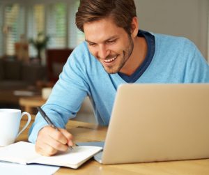Small business owner sitting looking at his blogging results, and looking very happy.