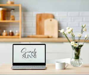 A view from the kitchen desk remodel ideas of a desk with open laptop and a vase of flowers.