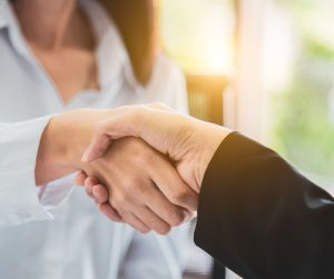 A business women shake hands in the morning for How Successful entreprenuers start their days.
