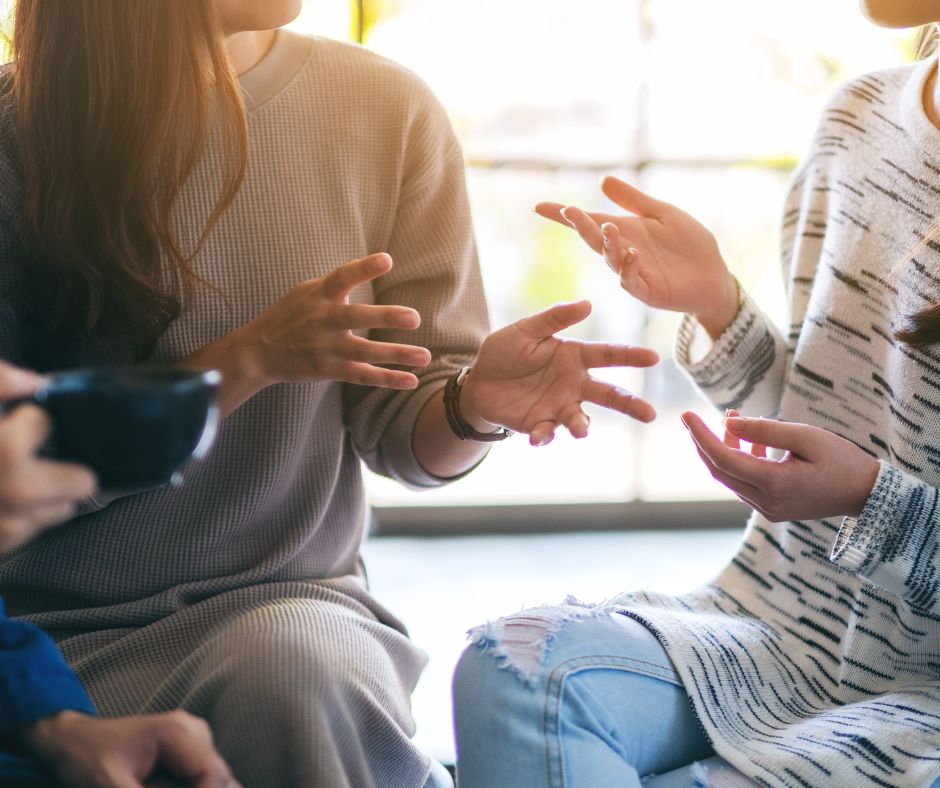 Featured image of a group of people taliking to illustrate conversational tone for beginner bloggers.